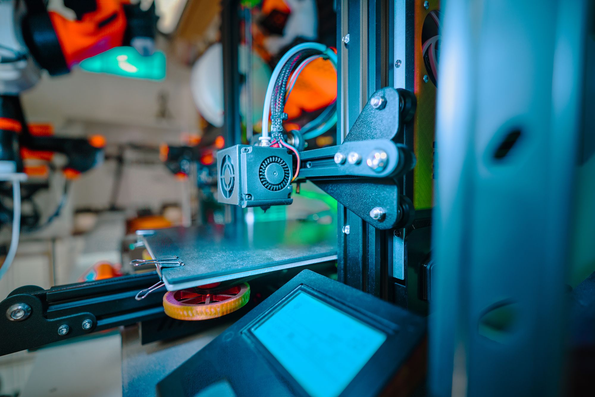 Close-up of a 3D printer extruder working above its build platform.